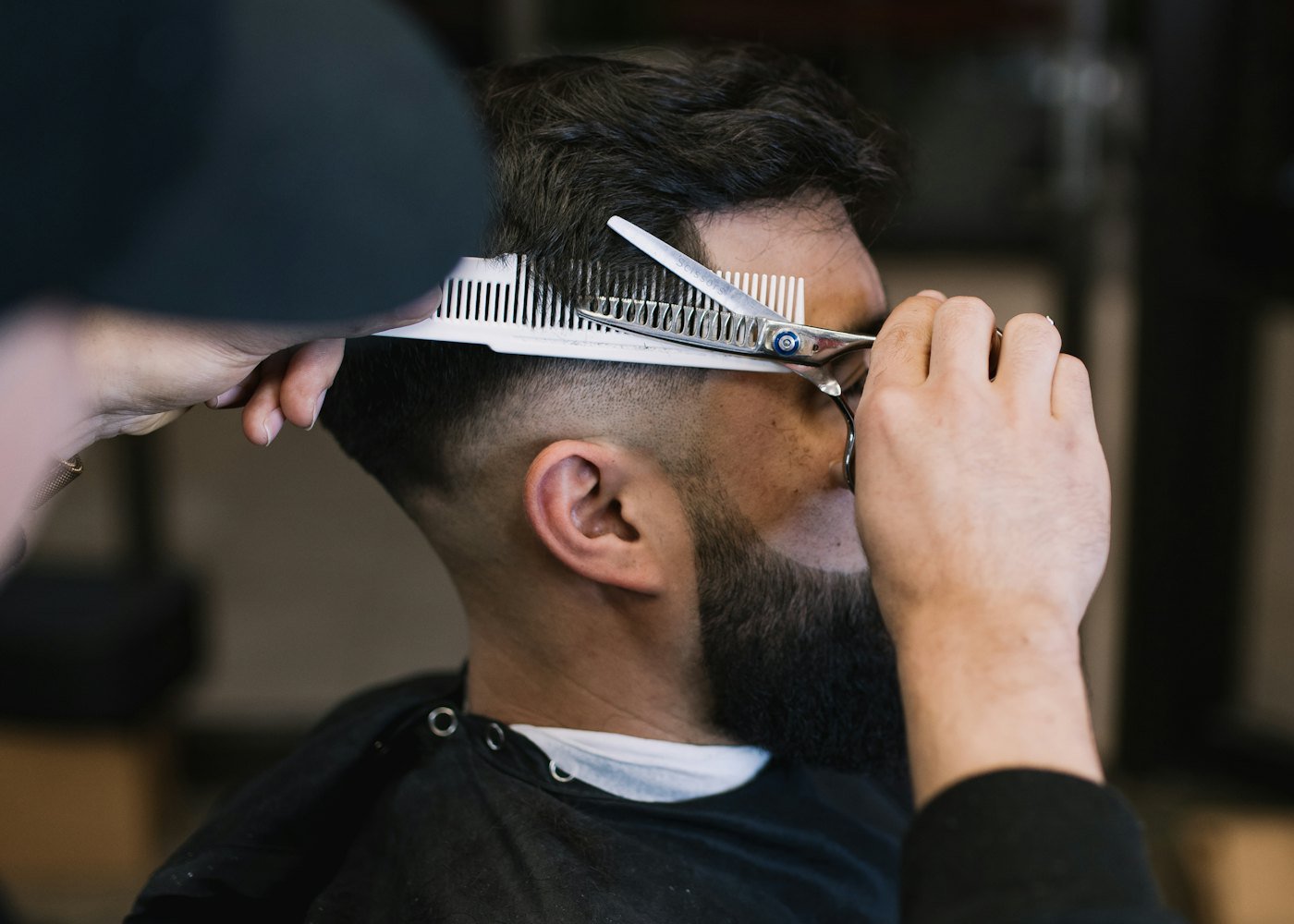 Barbeiro fazendo o corte de um cliente