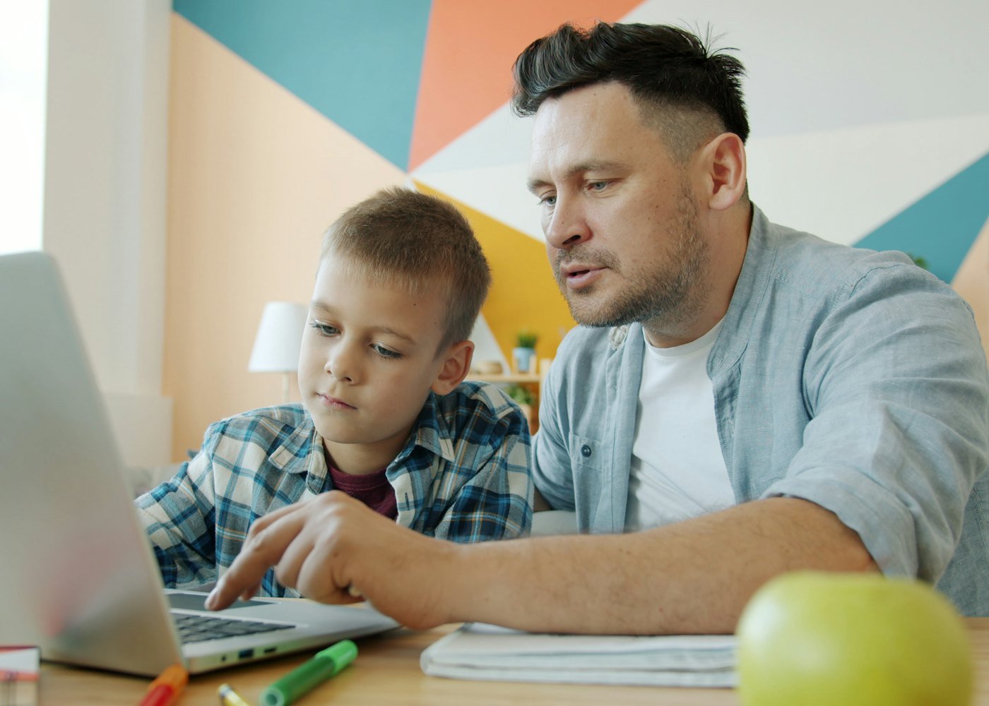 Pai acompanhando os estudos do filho pelo notebook